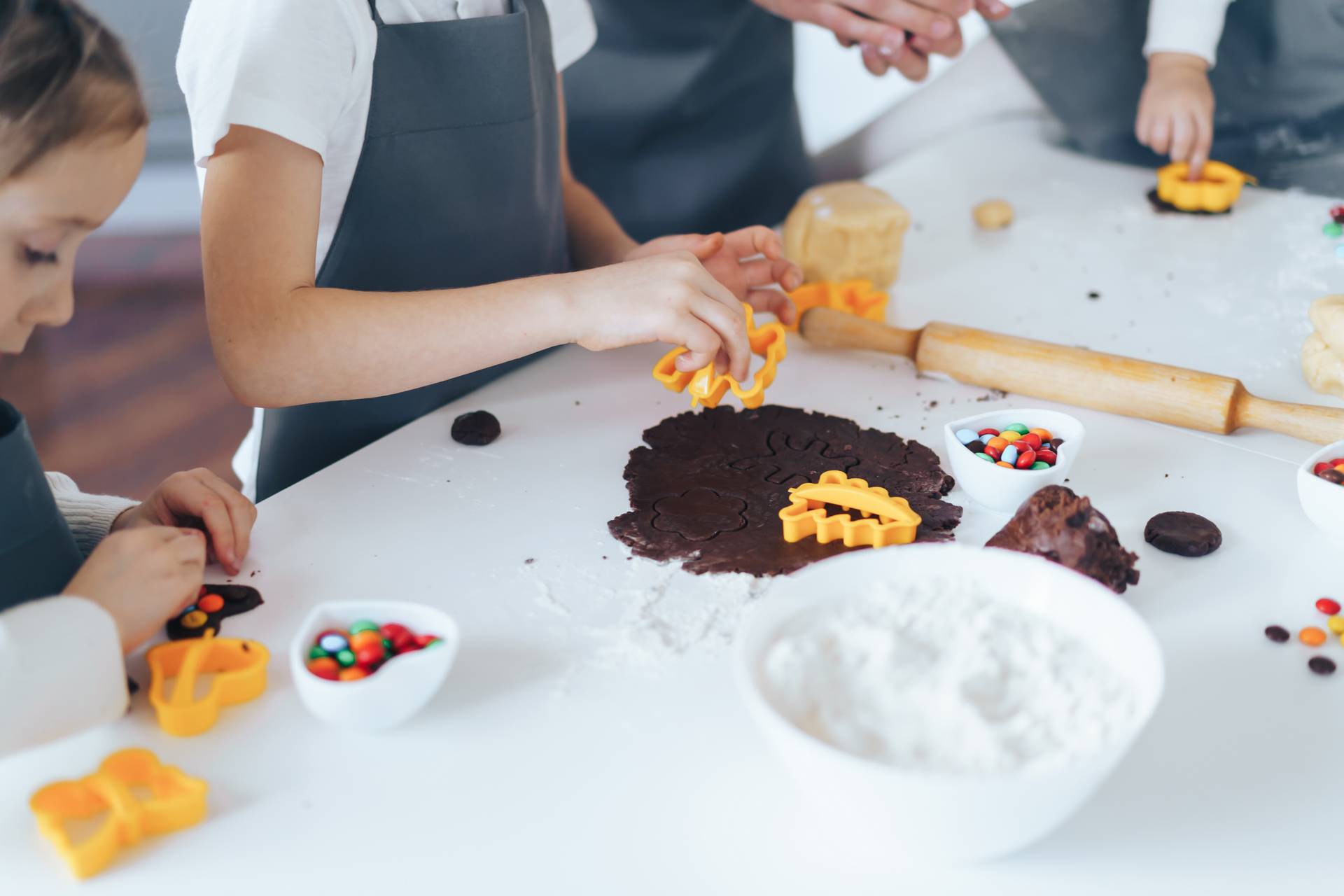 Large family is preparing cookies by squeezing molds from the dough. Leisure activity with children concept.